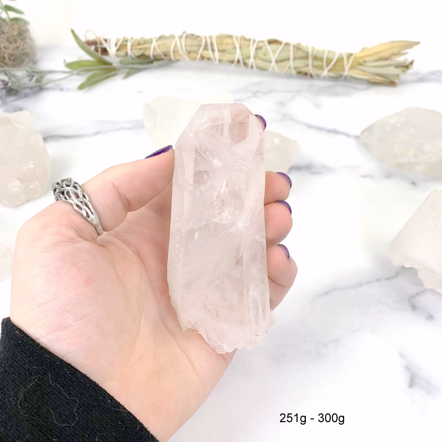 251gram - 300 gram lemurian quartz in hand with marble background