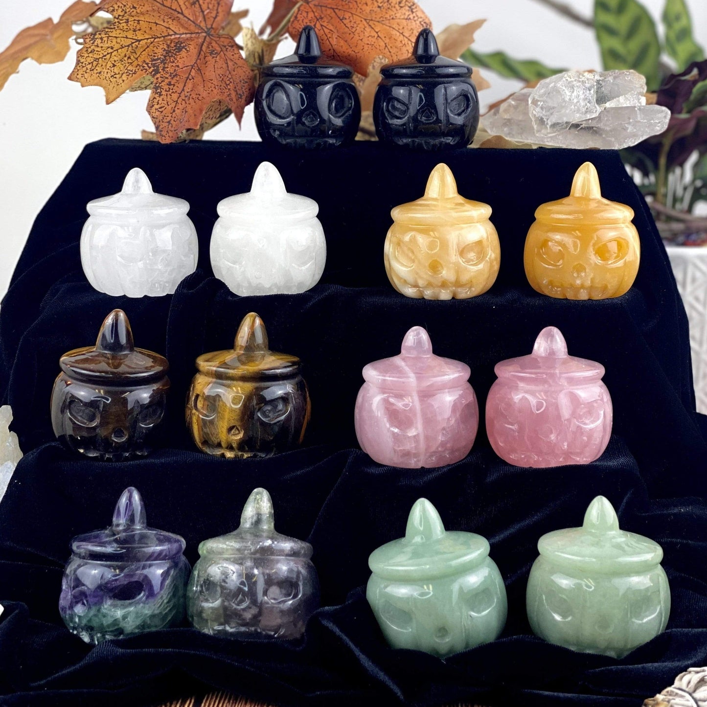 14 Carved Pumpkin Jack-o'-lantern Gemstones , 2 of each available stone, displayed on a dark velvet surface.