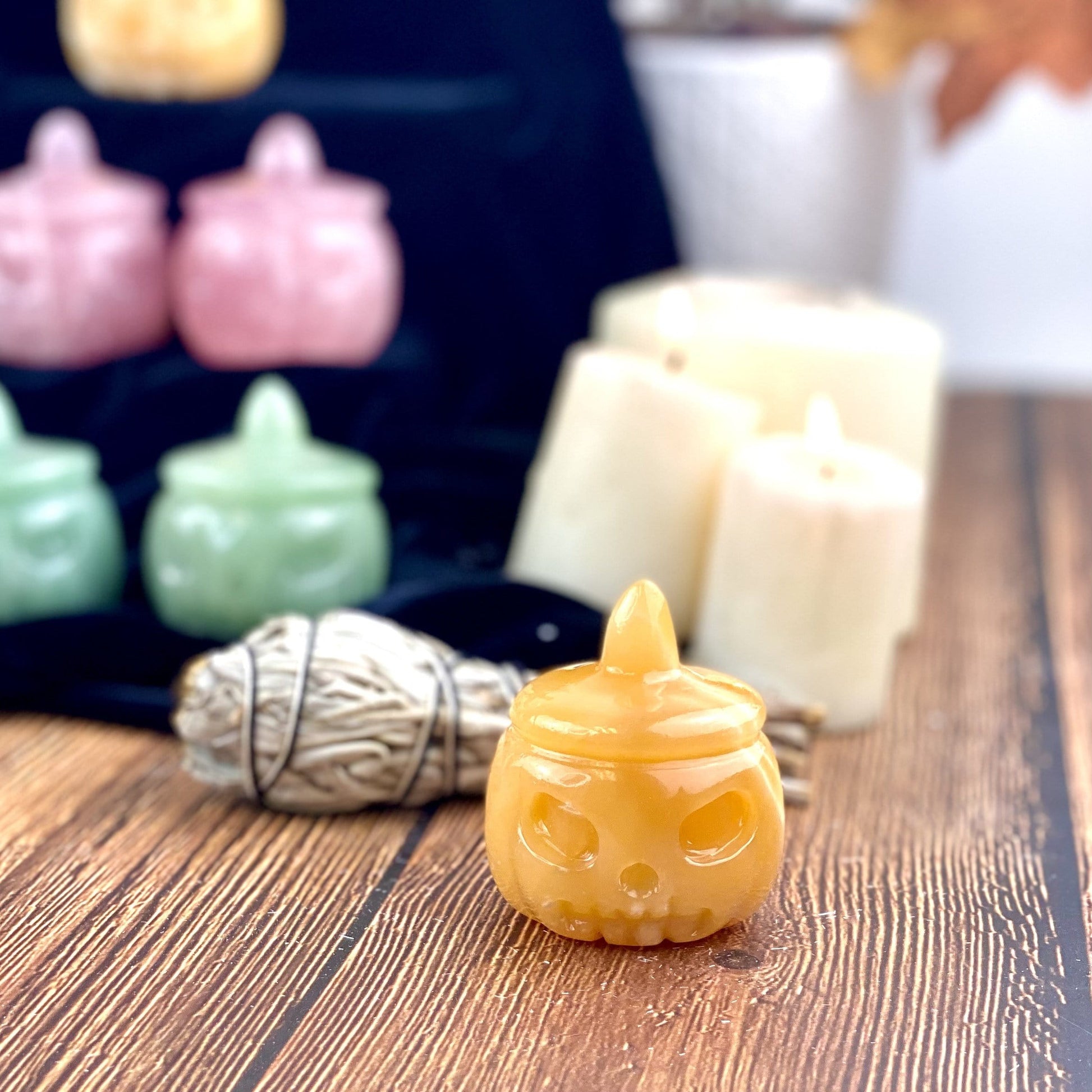 Frontal view of a Orange Citrine Carved Pumpkin Jack-o'-lantern Gemstone displayed on a wooden surface.