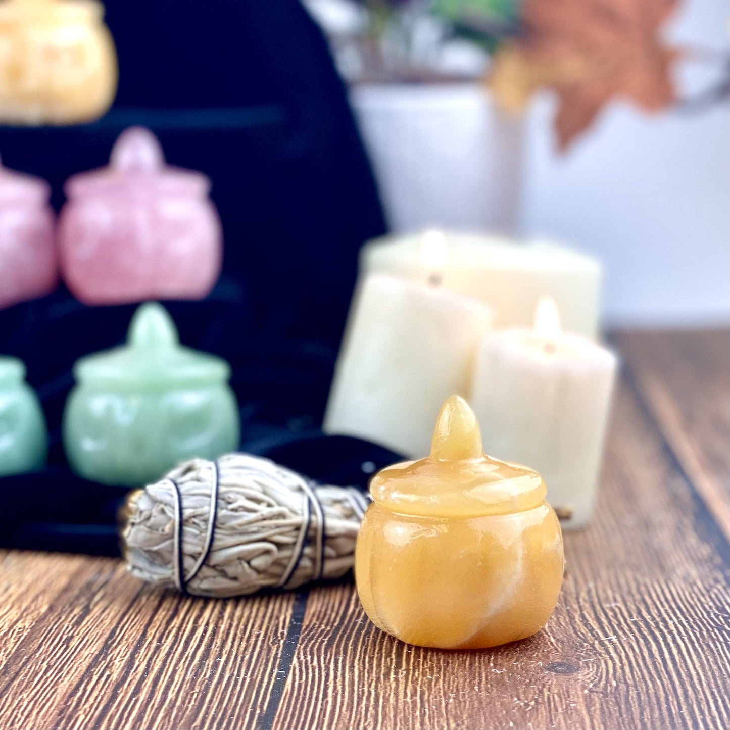 Back view of a Orange Citrine Carved Pumpkin Jack-o'-lantern Gemstone displayed on a wooden surface.
