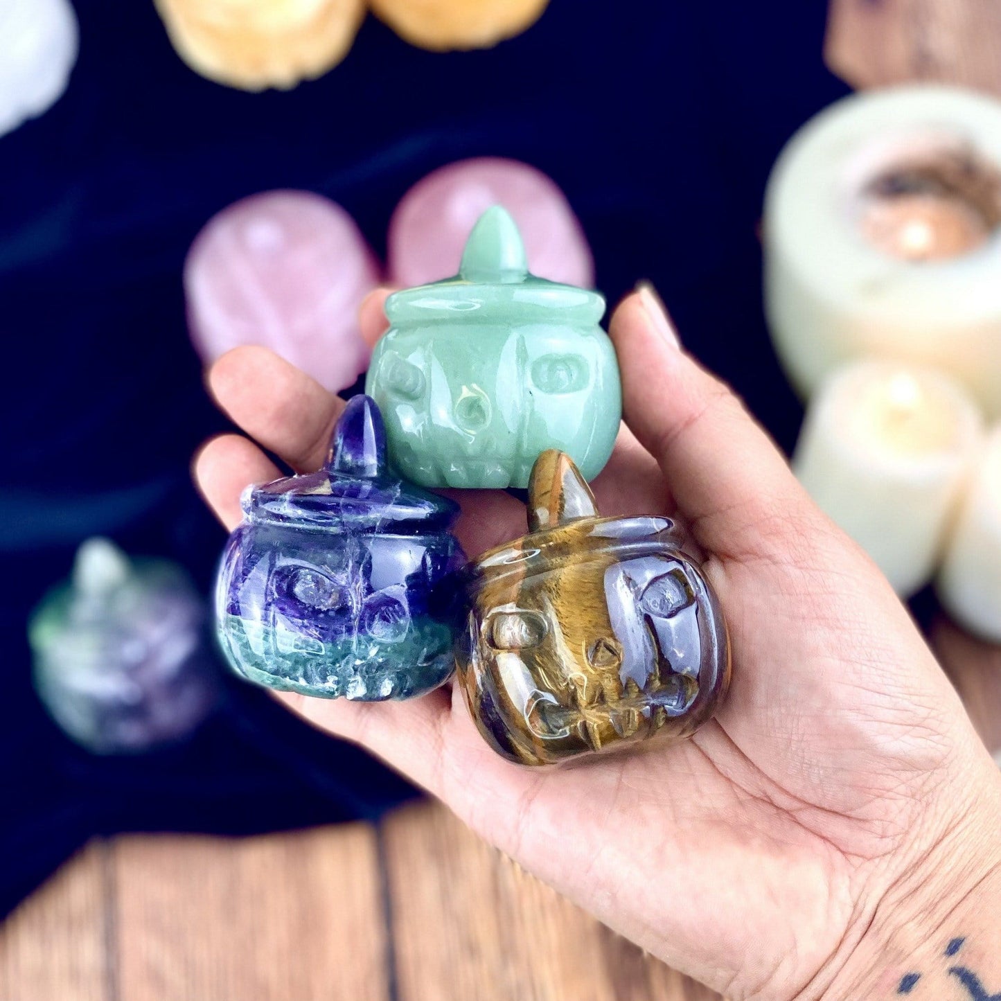Fluorite, Green Aventurine and Tigers Eye Carved Pumpkin Jack-o'-lantern Gemstones held in a woman's hand. 