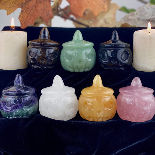 7 different Carved Pumpkin Jack-o'-lantern Gemstones displayed on a velvet surface.