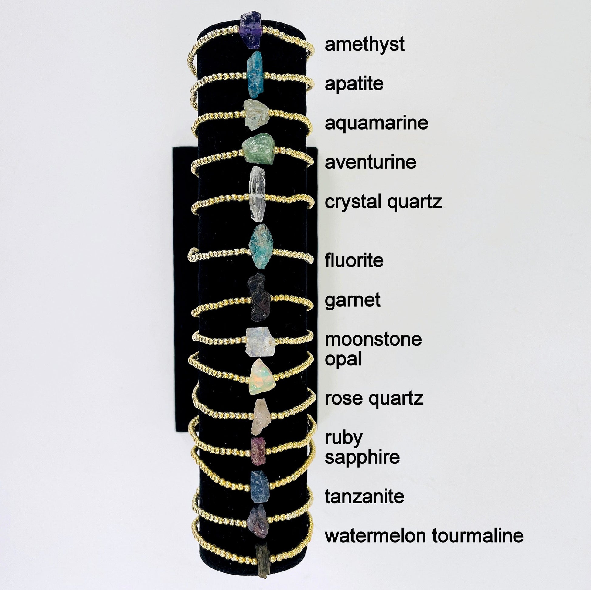 all gold rough stone bracelets on display with labels 