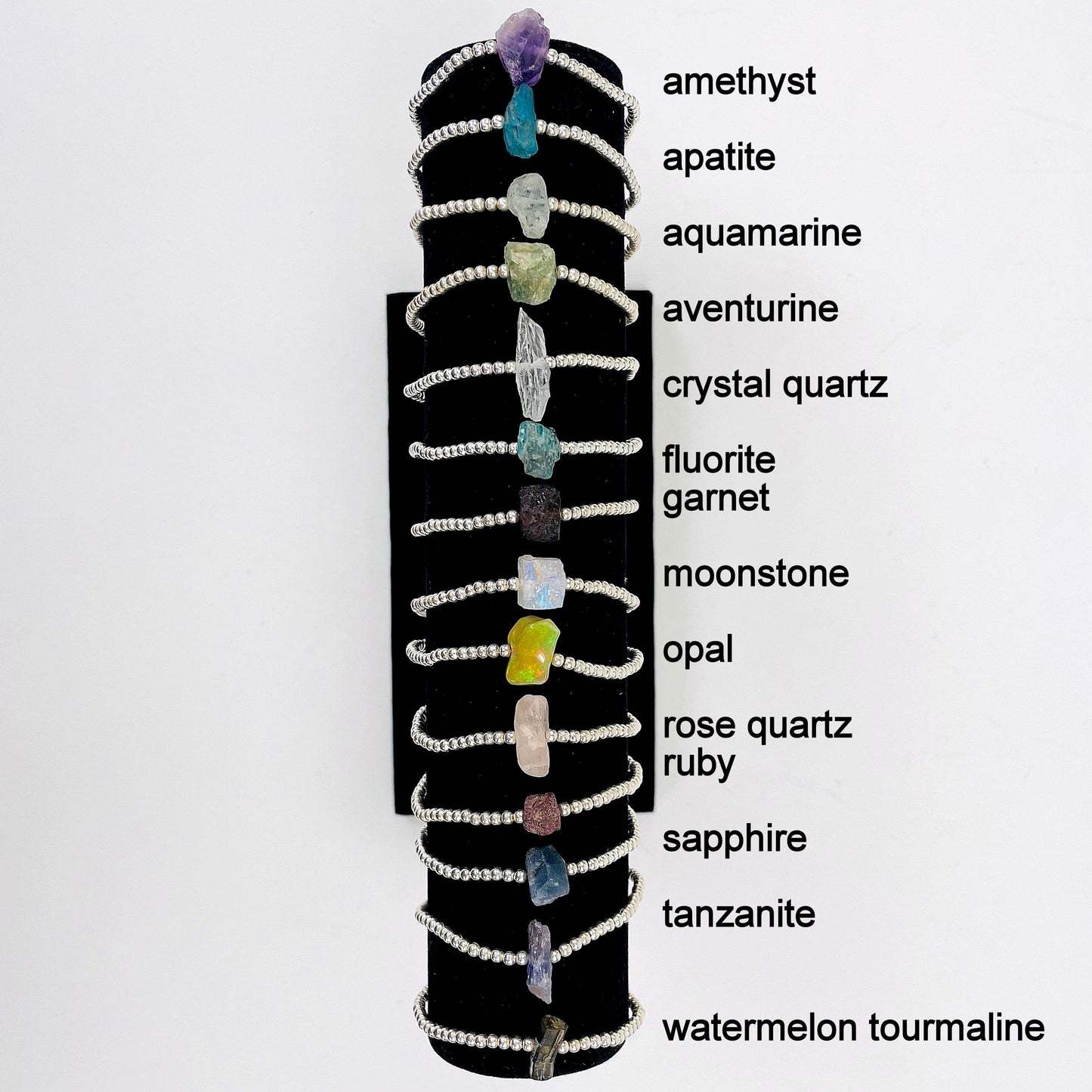 all silver rough stone bracelets on display with labels 