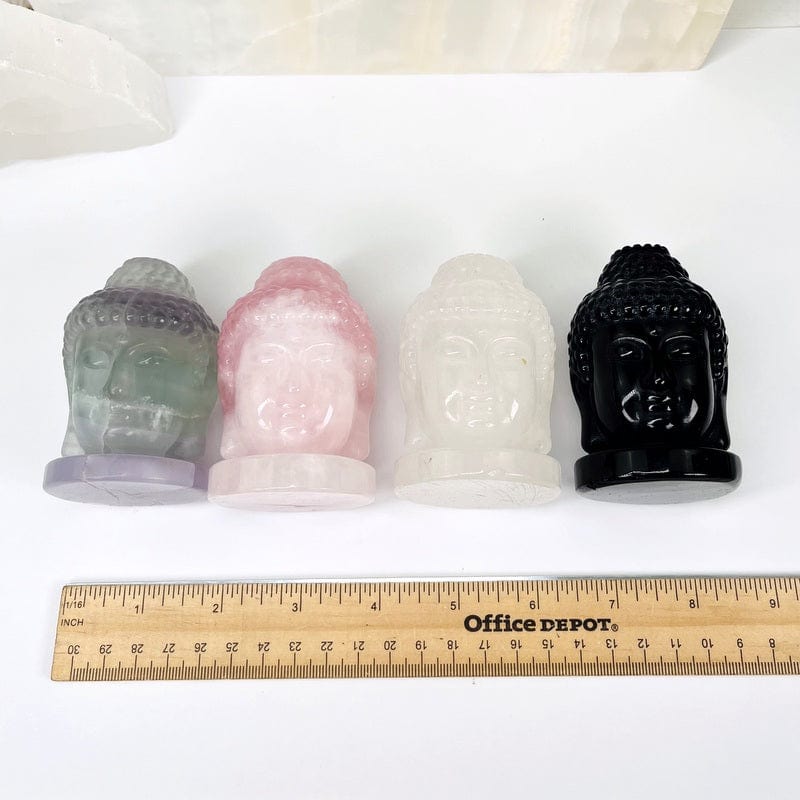 buddha heads next to a ruler for size reference 