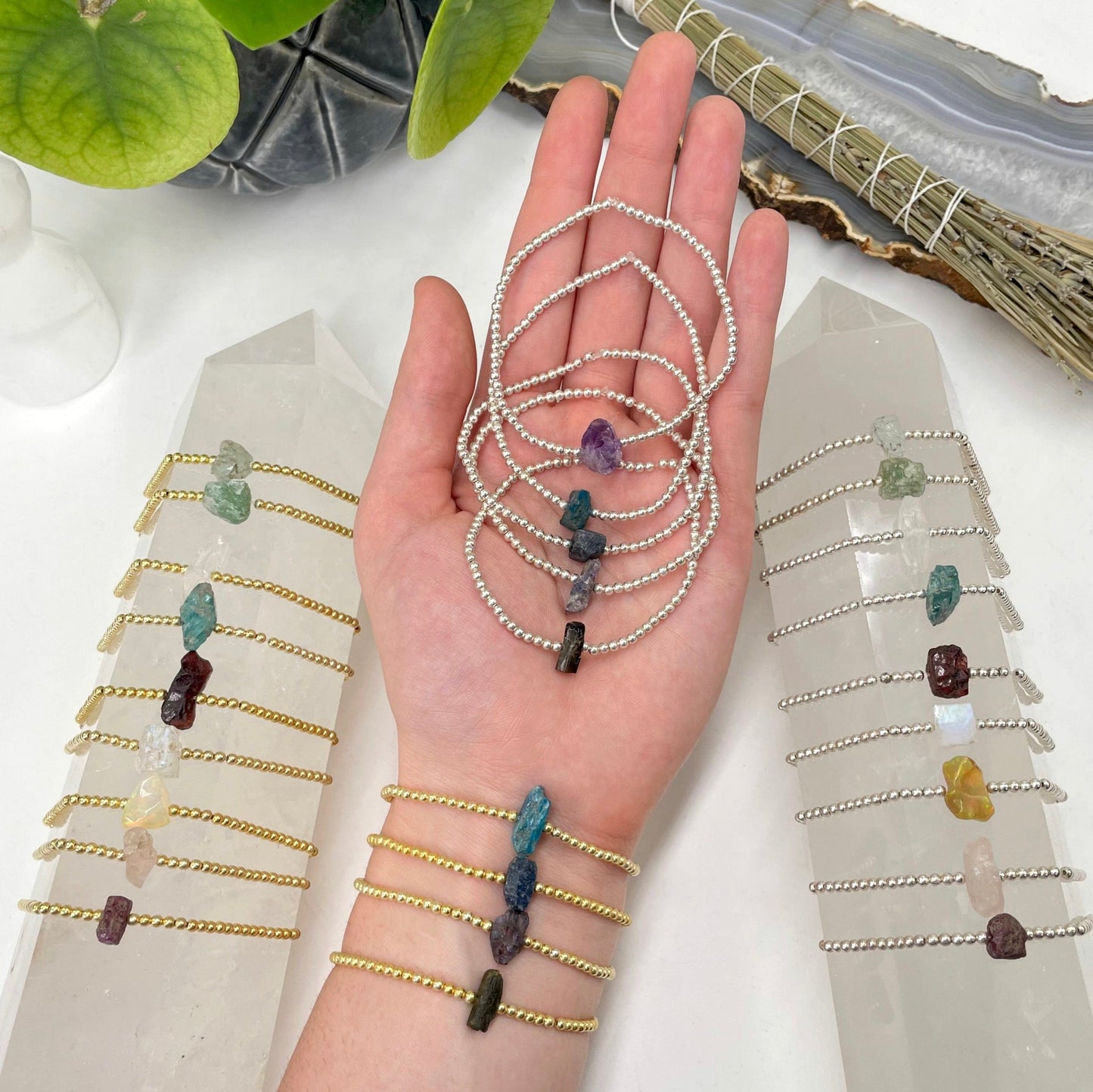 many rough stone bracelets in hand, on wrist, and on display for size reference and possible variations