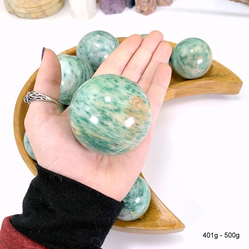 401 gram - 500 gram fuchsite sphere in hand with white background