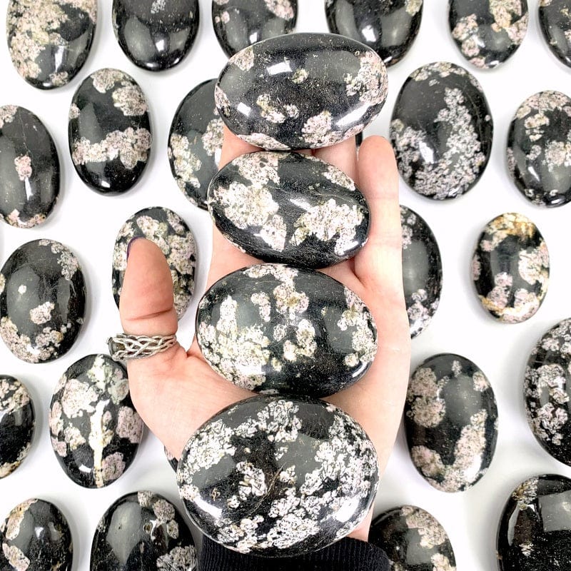 4 stones in hand with more in the background