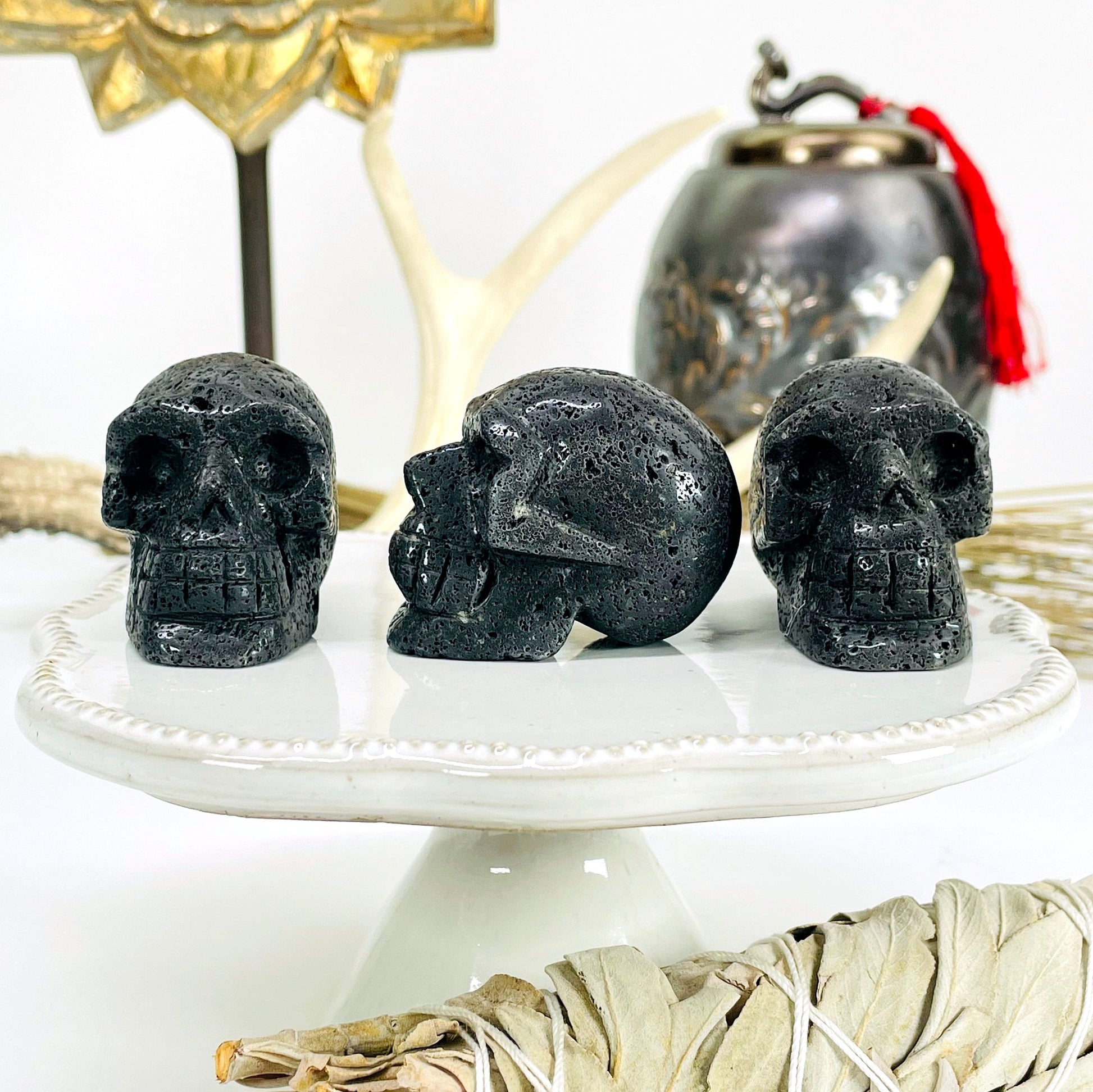 three lava skull heads on display in front of backdrop with one turned to the side for side details and thickness