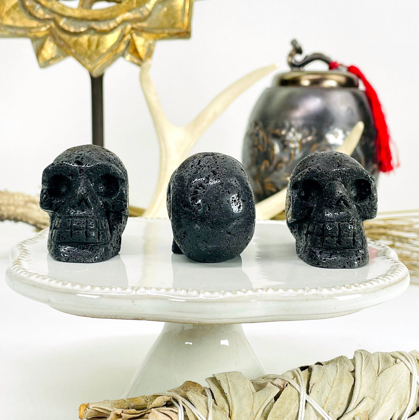 three lava skull heads on display in front of backdrop with one turned to the back