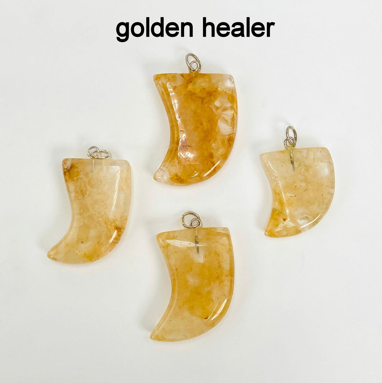 close up of four tumbled golden agate horn pendants on white background for details and possible variations