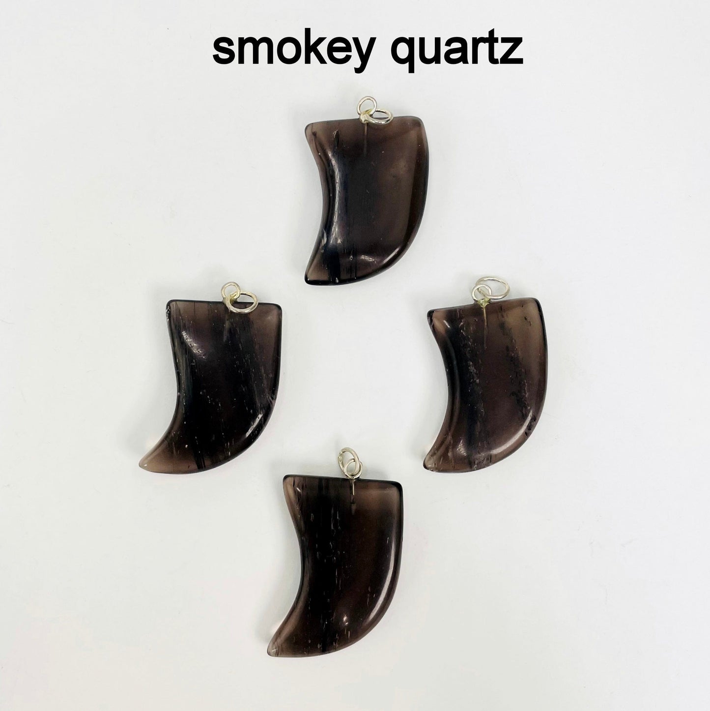close up of four tumbled smokey quartz horn pendants on white background for details and possible variations