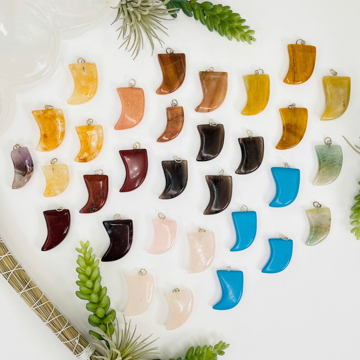 overhead view of all tumbled horn pendant options on white background with plant decorations for possible variations