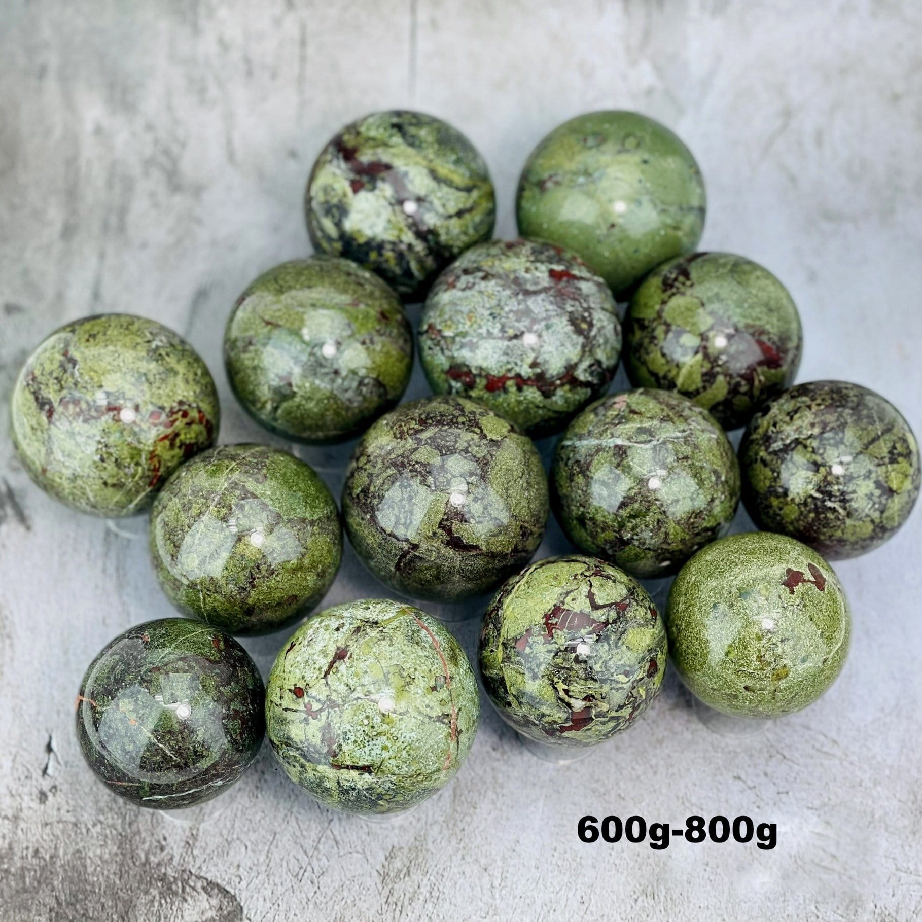 Multiples Dragon Blood Stone Spheres on Gray Background.
