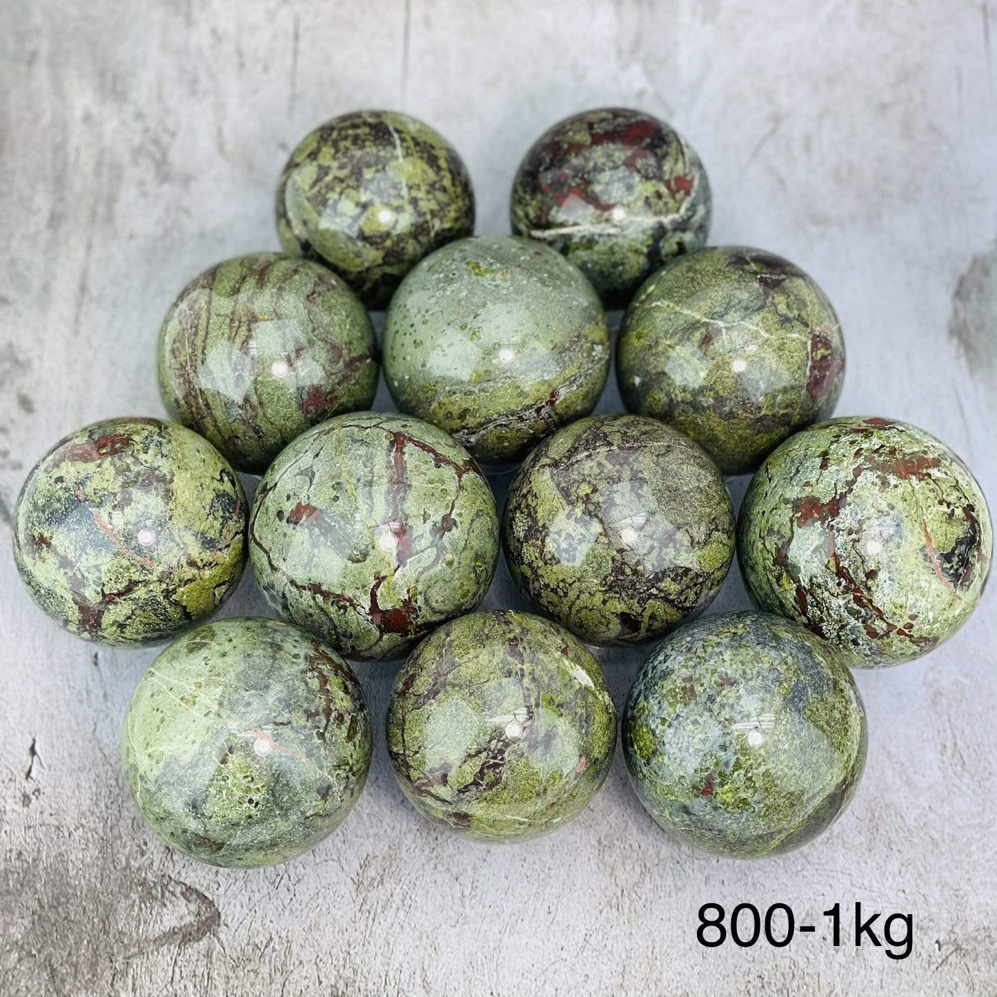 Multiples Dragon Blood Stone Spheres on Gray Background. 