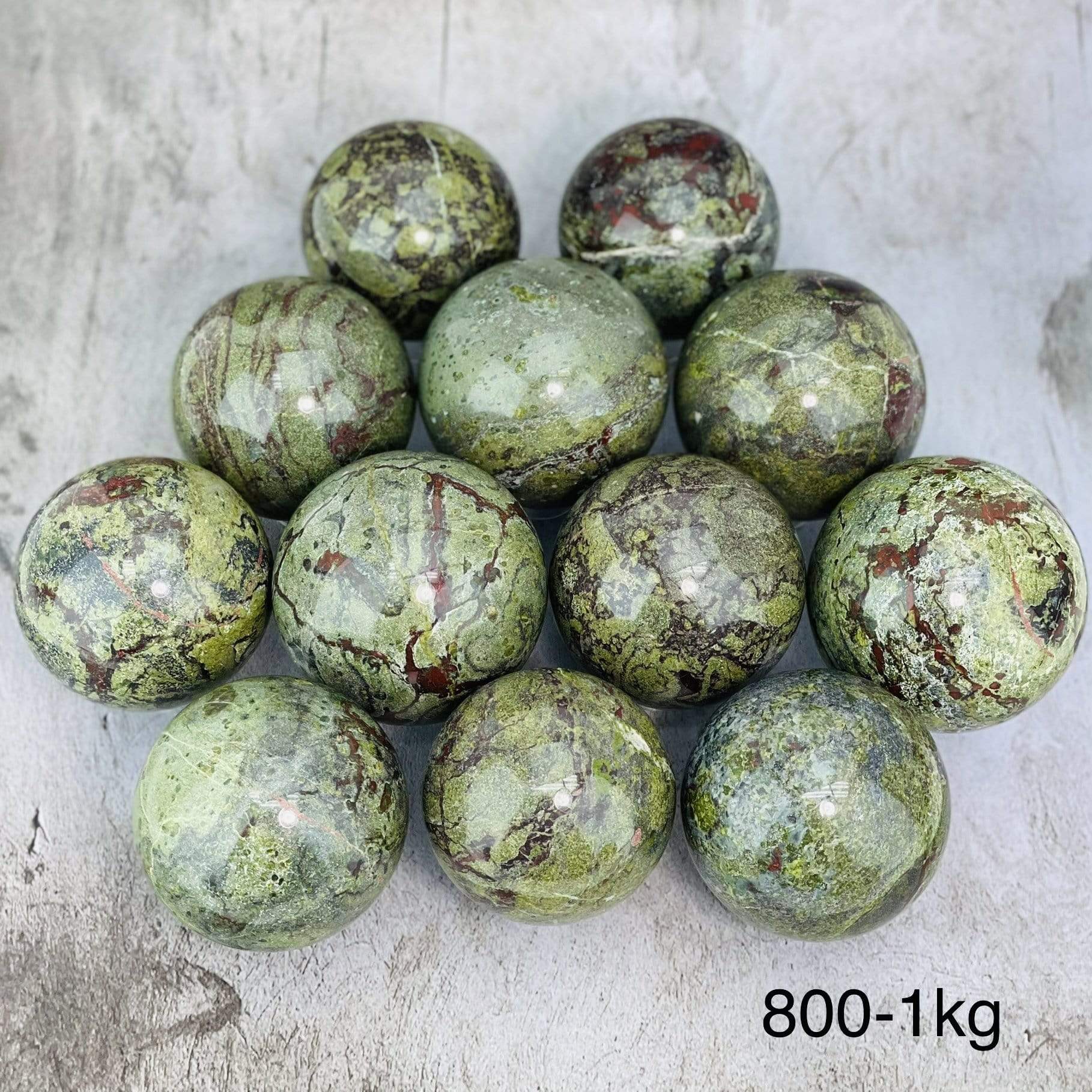 Multiples Dragon Blood Stone Spheres on Gray Background. 