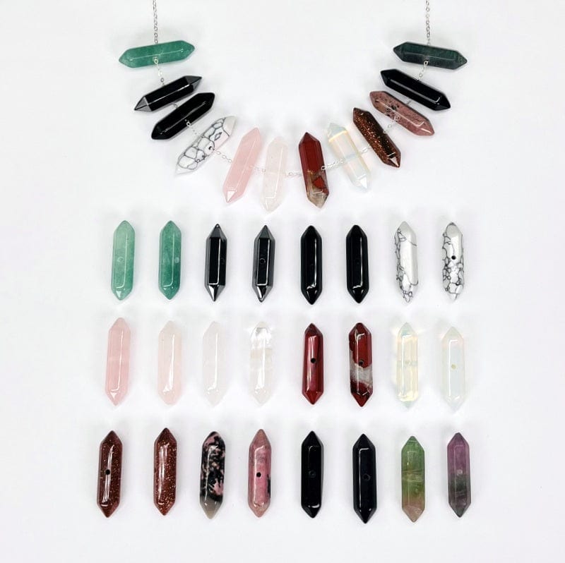 multiple double terminated pencil point beads with a center drill hole displayed to show the differences in the stone options