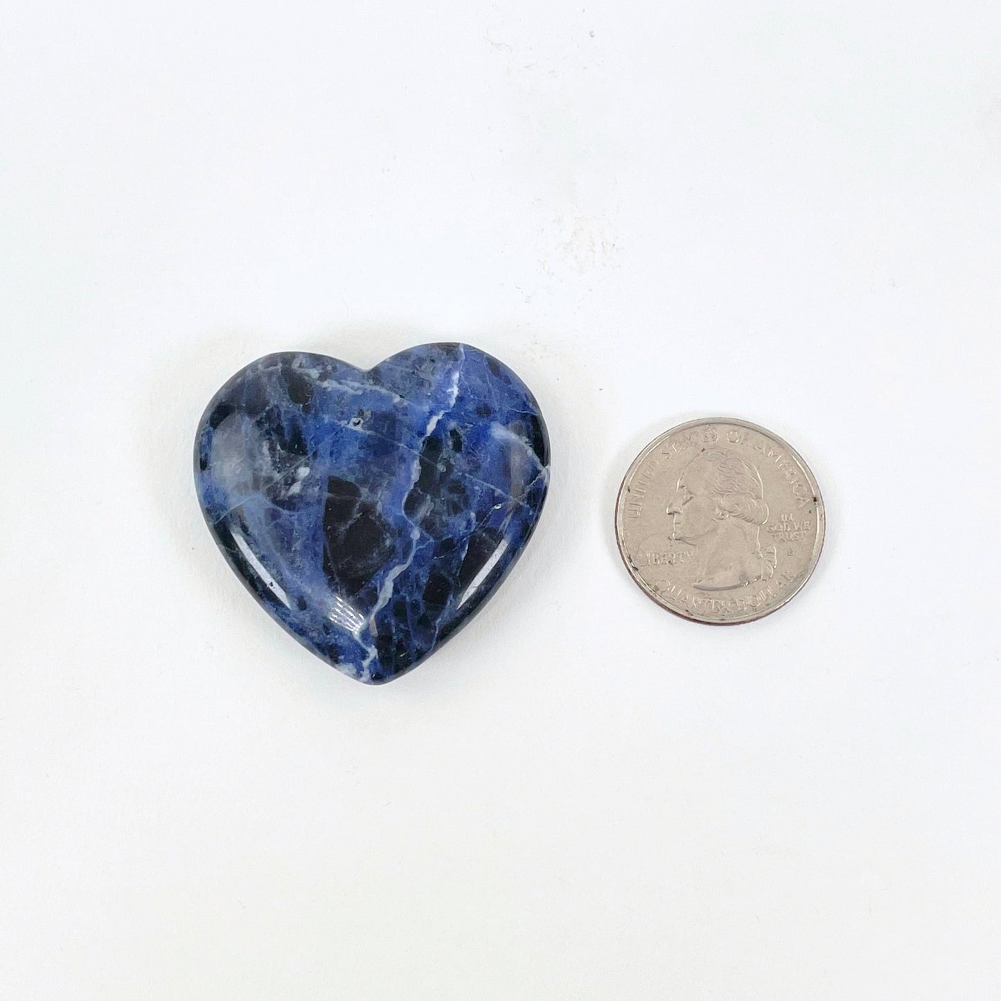 close up of sodalite polished herat with quarter