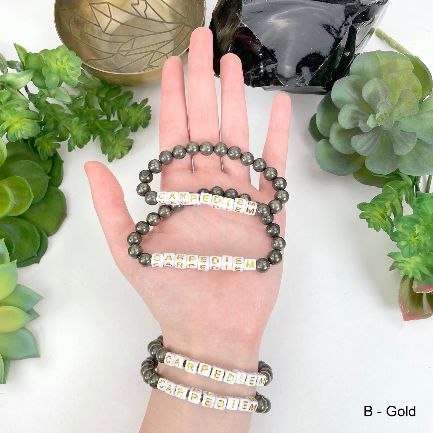 gold "CARPEDIEM" letter bead option in hand and on wrist for color reference
