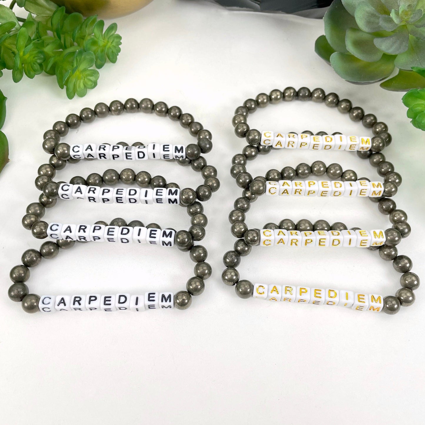 black "CARPEDIEM" letter beads on left display and gold "CARPEDIEM" letter beads on right display