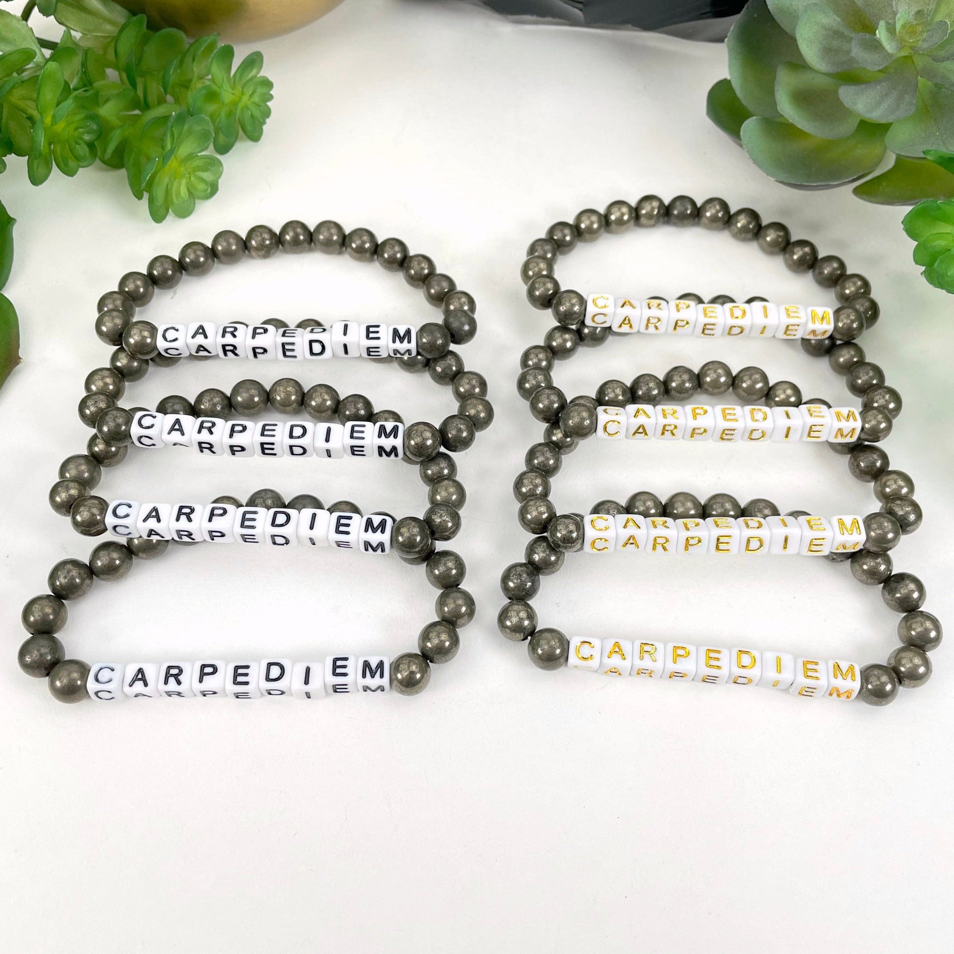 black "CARPEDIEM" letter beads on left display and gold "CARPEDIEM" letter beads on right display