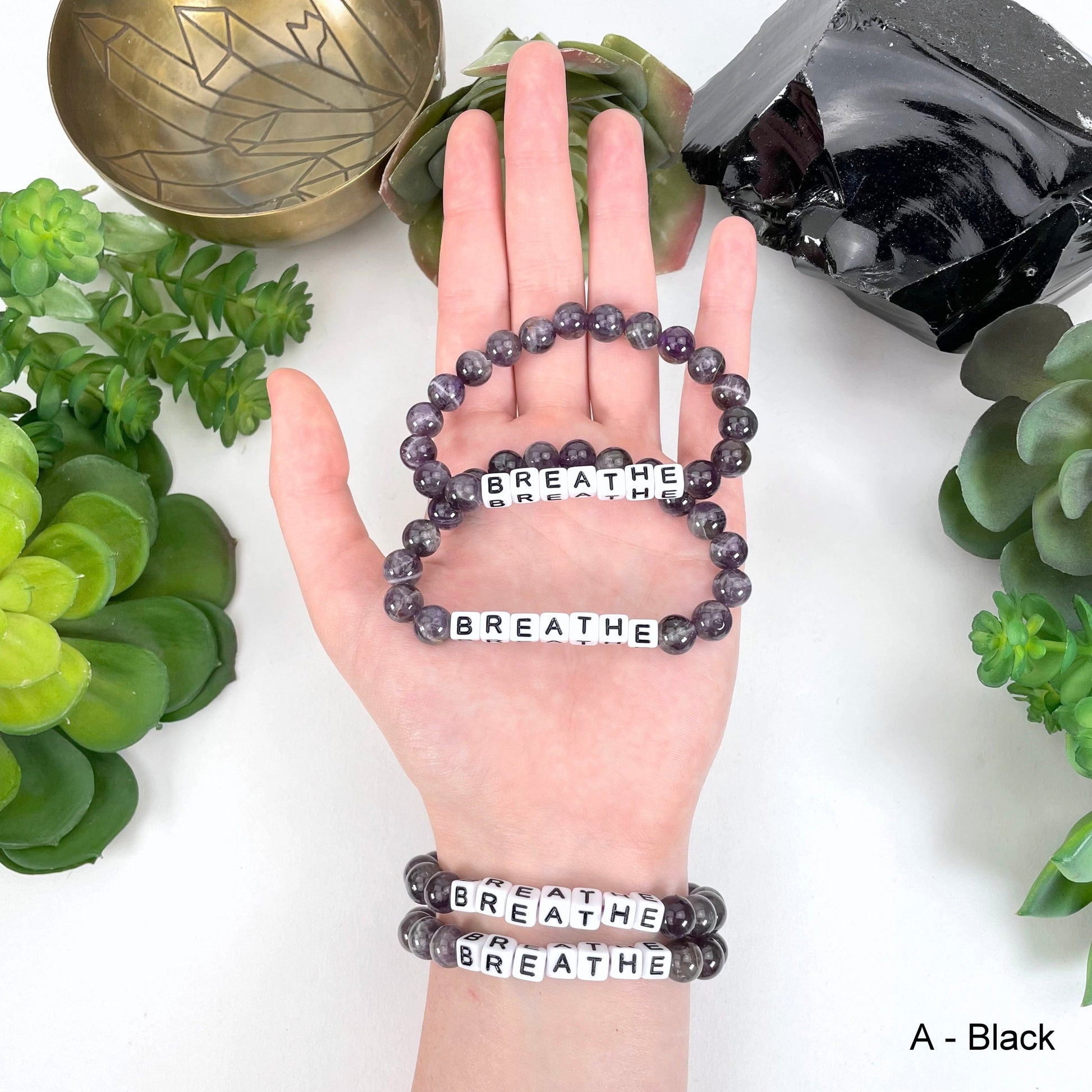 black "BREATHE" letter bead option in hand and on wrist for color reference