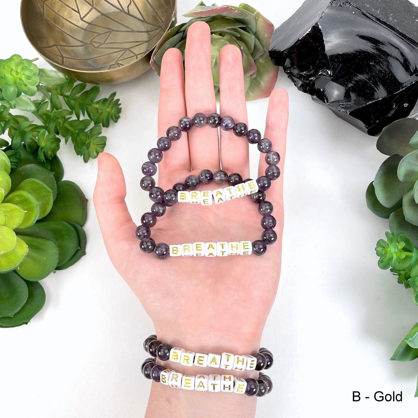 gold "BREATHE" letter bead option in hand and on wrist for color reference