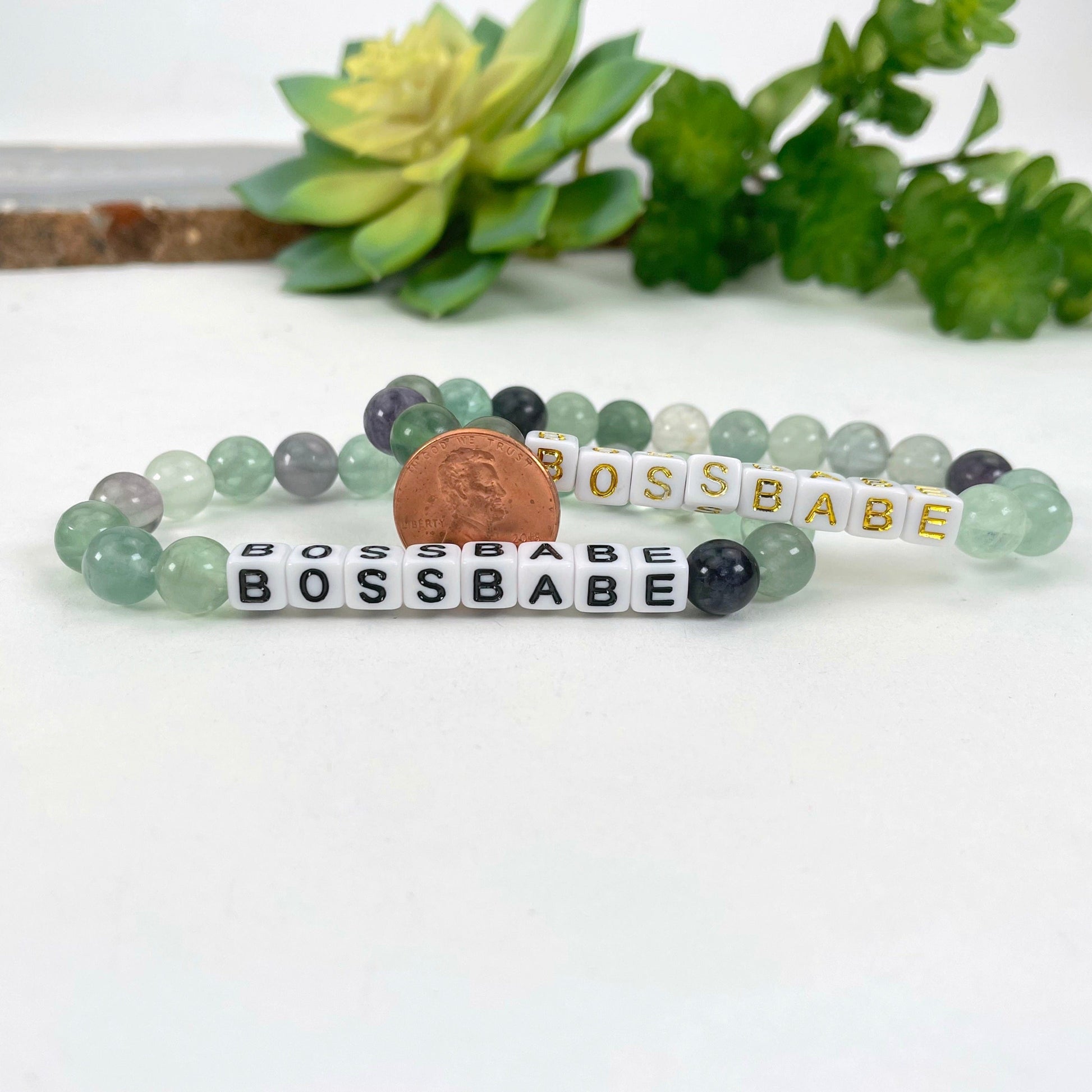 close up of fluorite beaded bracelets with penny for size reference