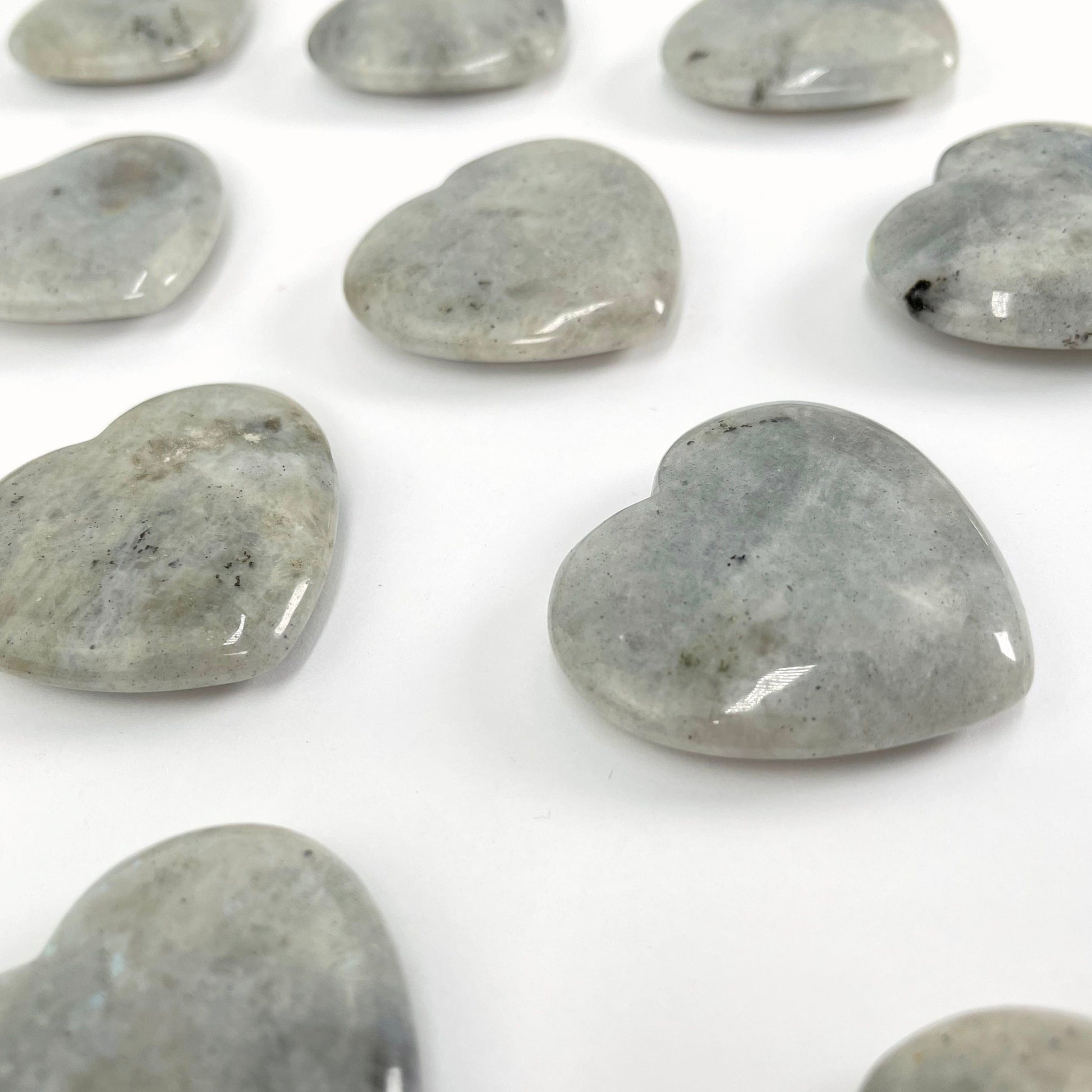 angled view of grey moonstone polished hearts for thickness