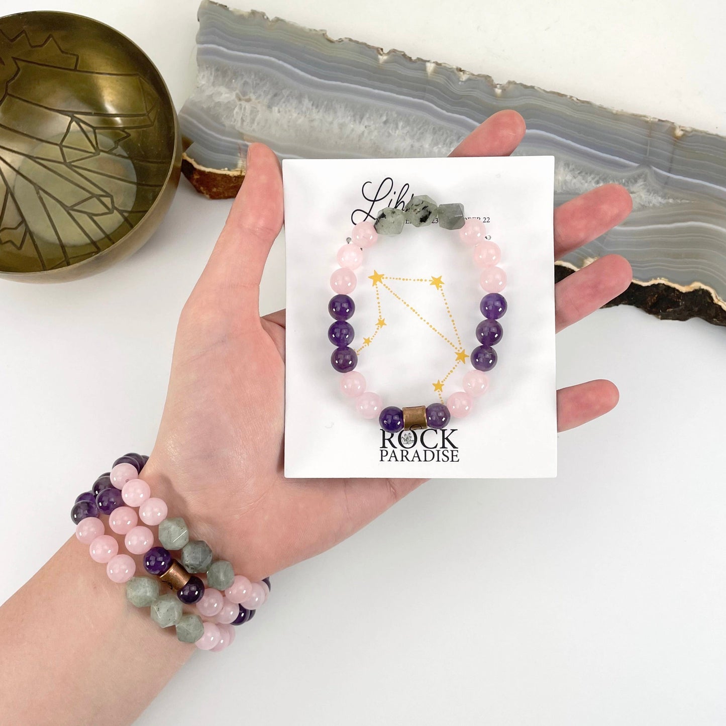 packaged libra zodiac bracelet in hand with libra zodiac bracelets on wrist