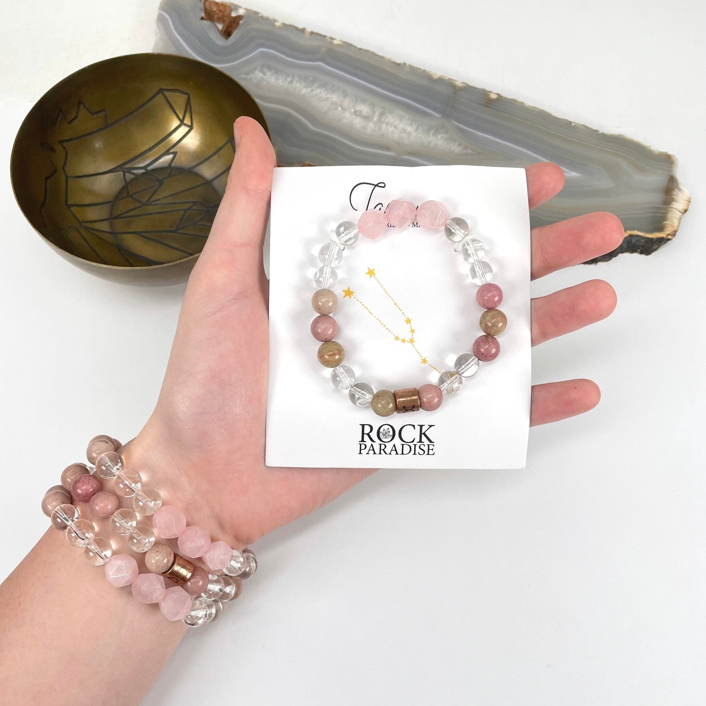 packaged taurus zodiac bracelet in hand with taurus zodiac bracelets on wrist