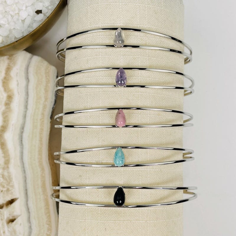 close up of all the silver droplet bracelets in silver 