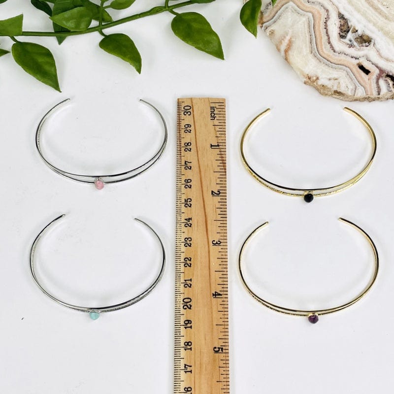 bracelets next to a ruler for size reference 