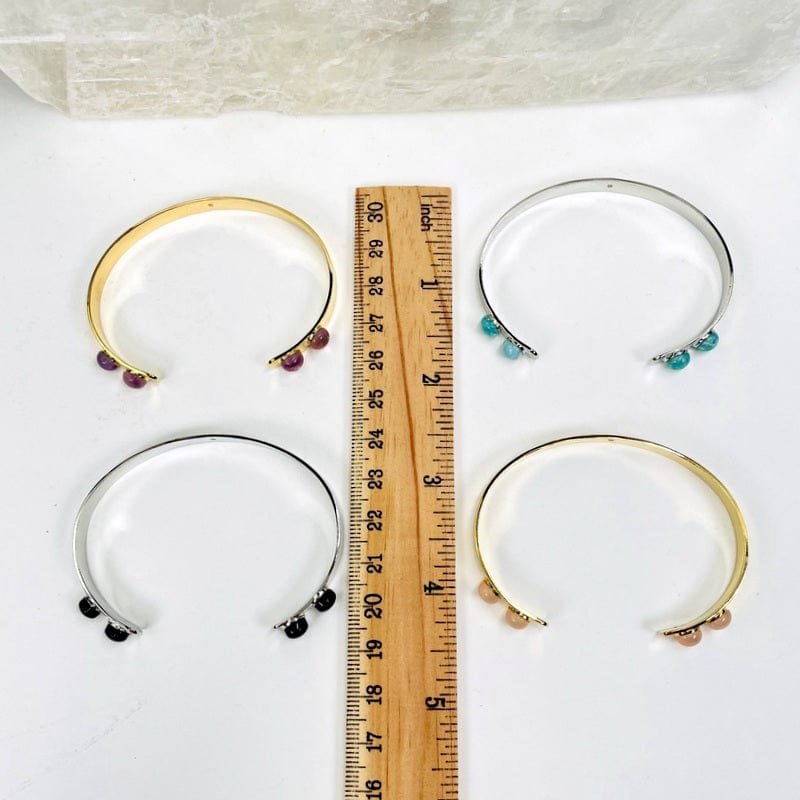 bracelets next to a ruler for size reference 