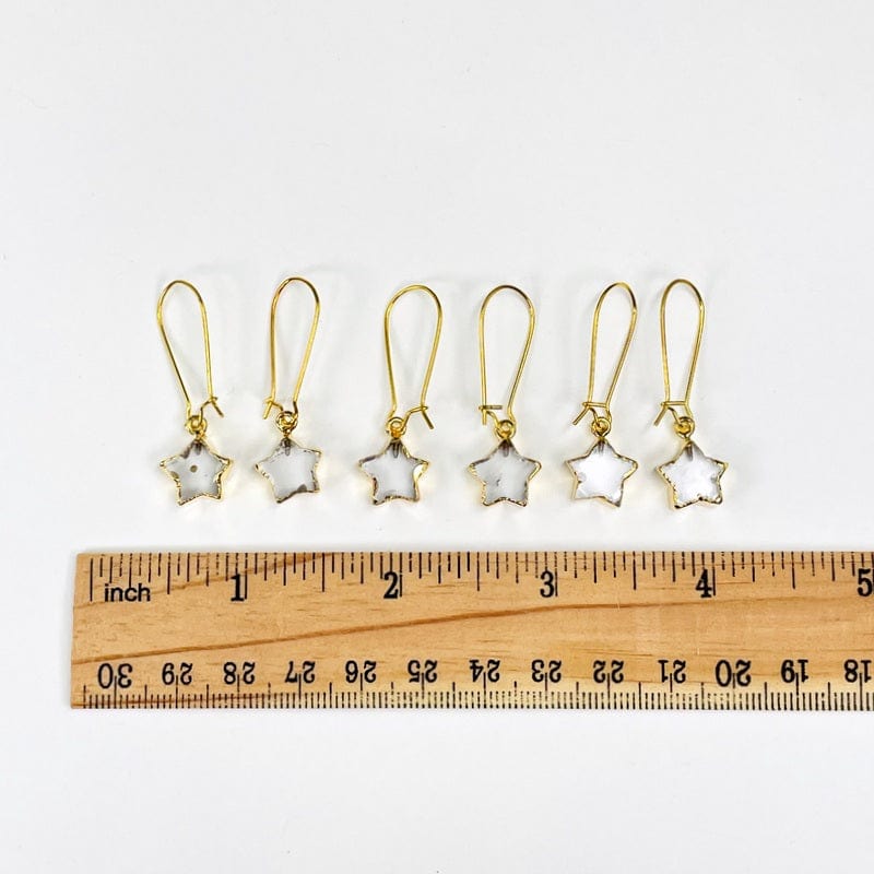 earrings next to a ruler for size reference 