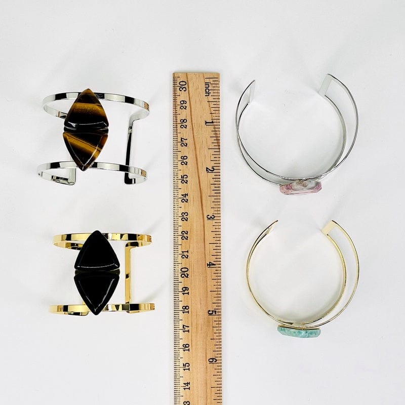cuff bracelets next to a ruler for size reference 