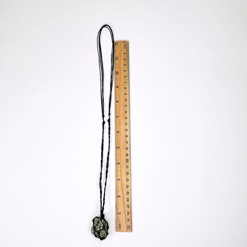 necklace next to a ruler for size reference 