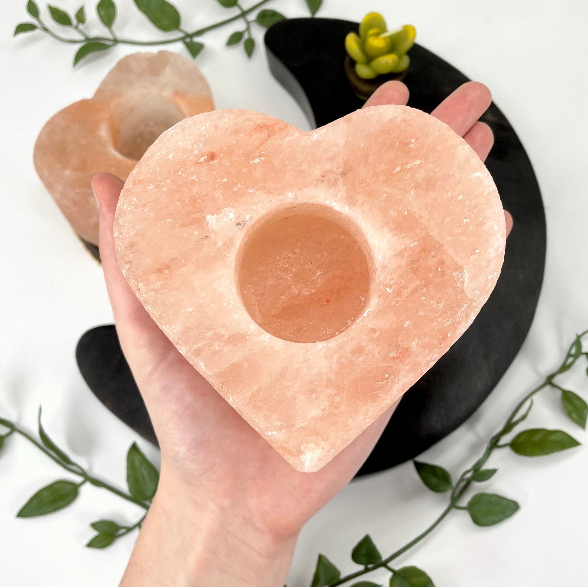 one himalayan salt orange heart candle holder in hand for size reference with another in background display