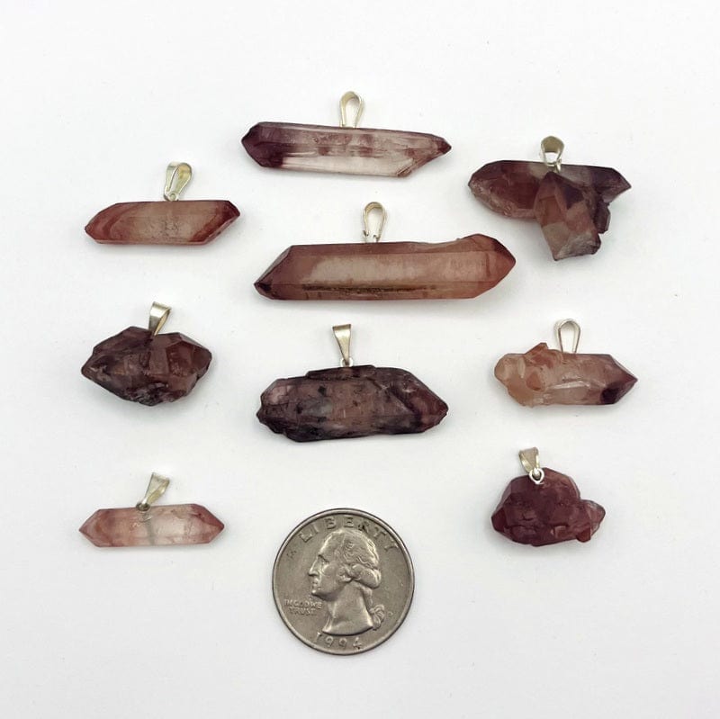 double terminated lithium quartz point pendants next to a quarter for size reference 