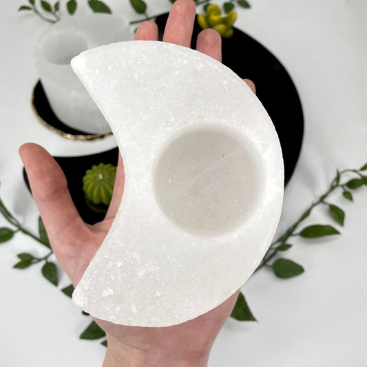 one himalayan salt white moon candle holder in hand for size reference with another in background display