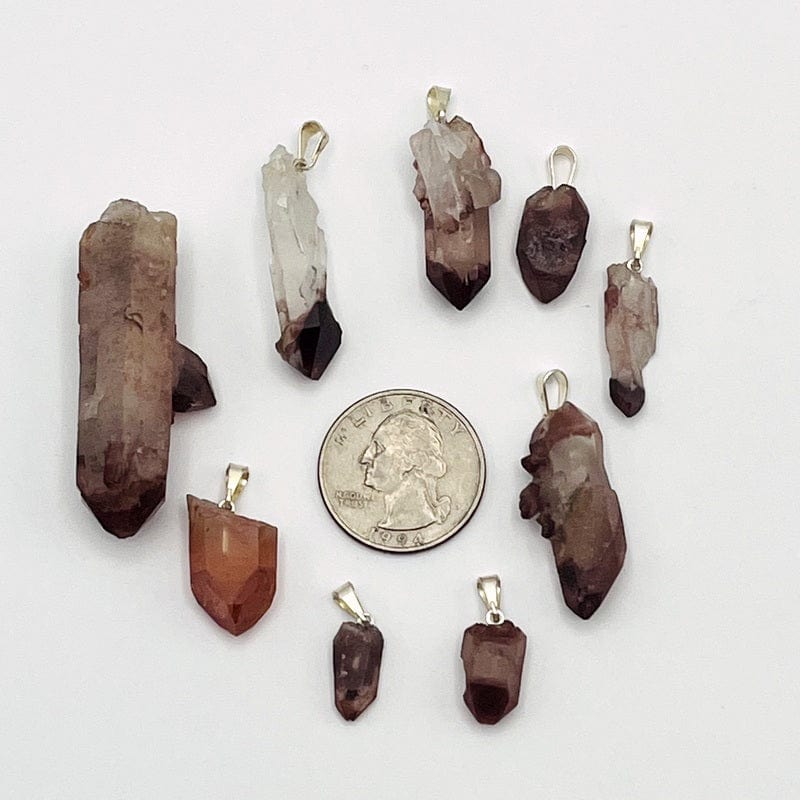 lithium quartz pencil point pendants next to a quarter for size reference 