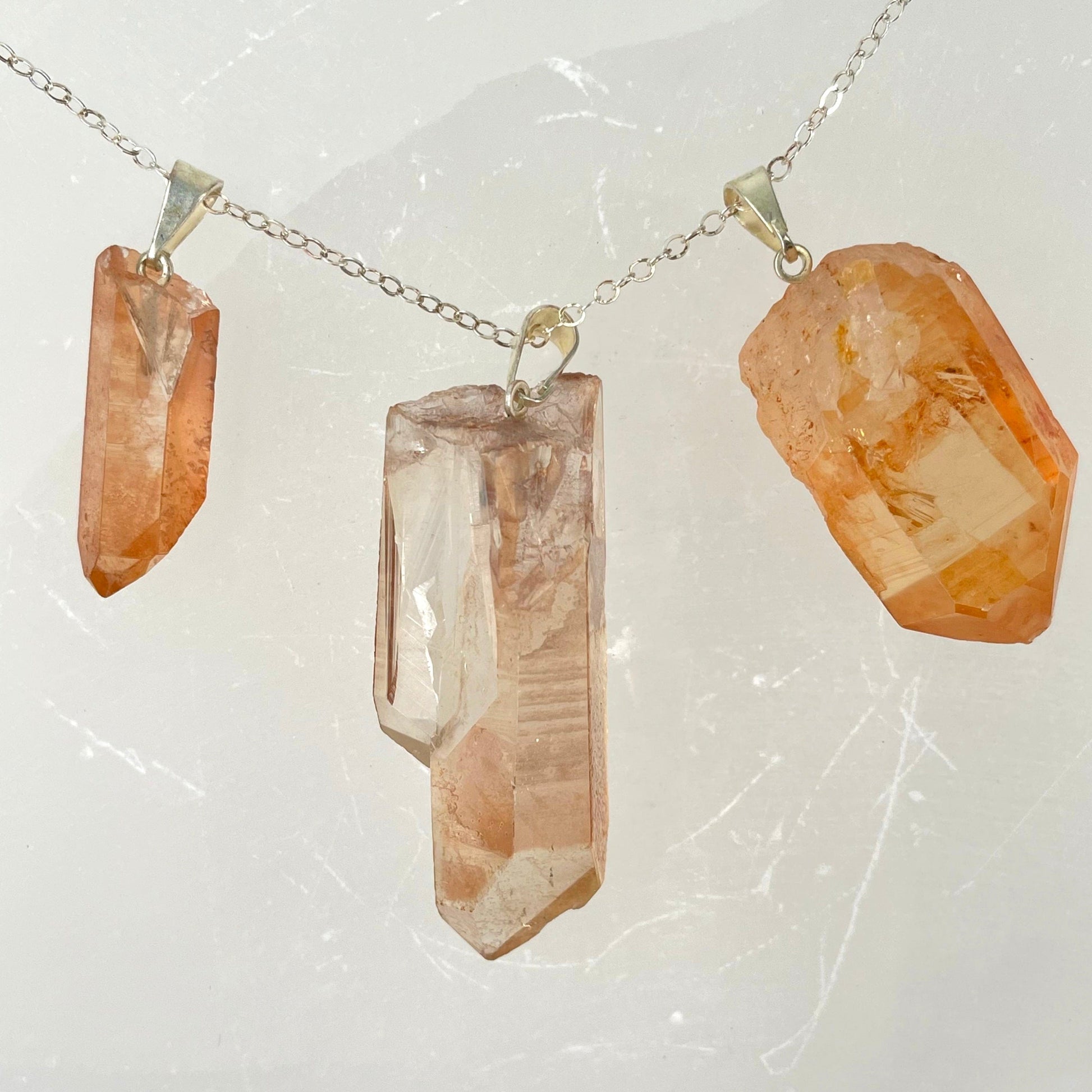 three tangerine rough point pendants on chain