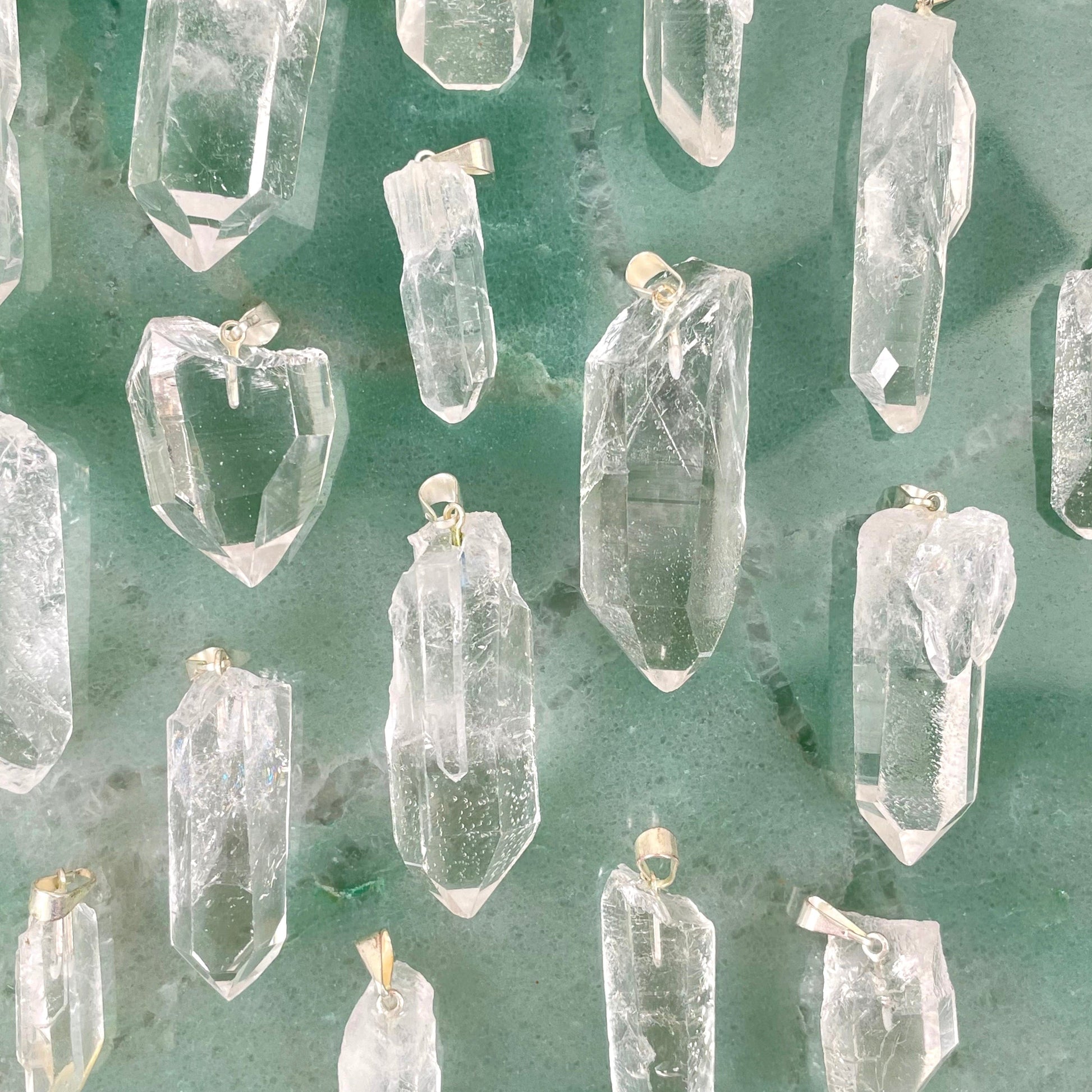 many crystal quartz rough point pendants on display for possible variations