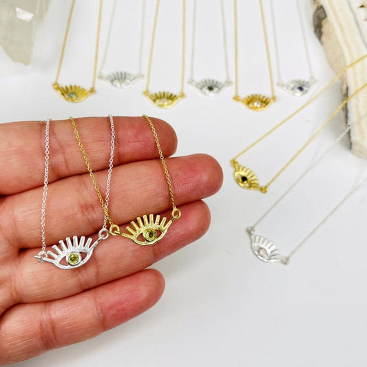 evil eye necklace pendants in hand for size reference 