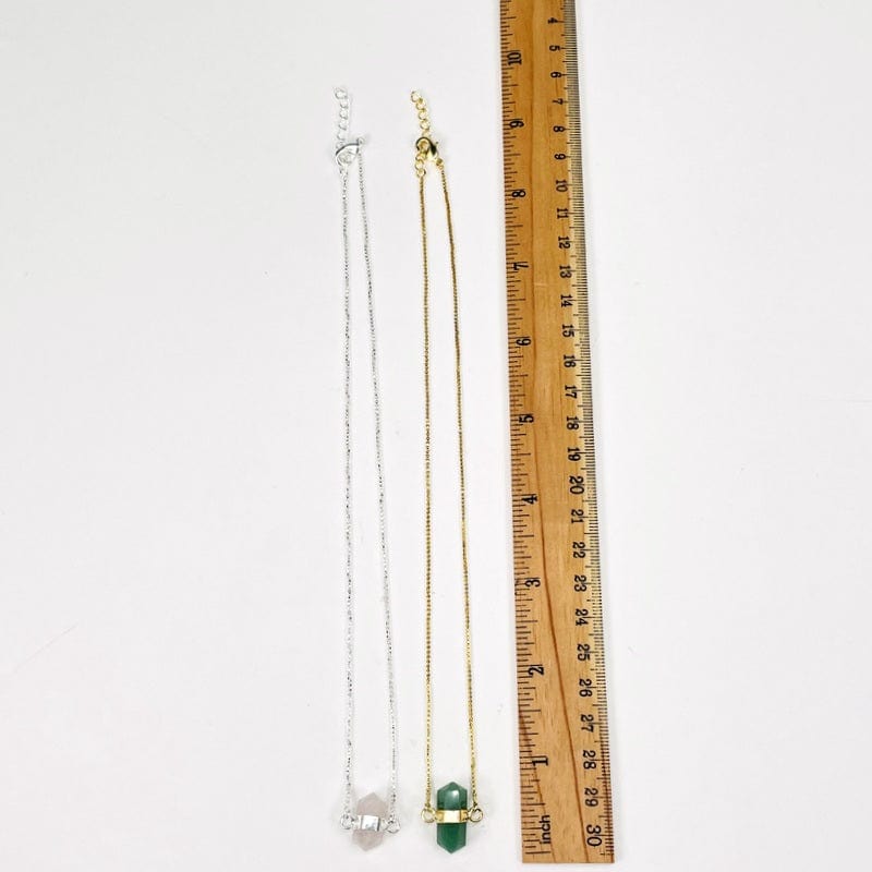 necklace next to a ruler for size reference 