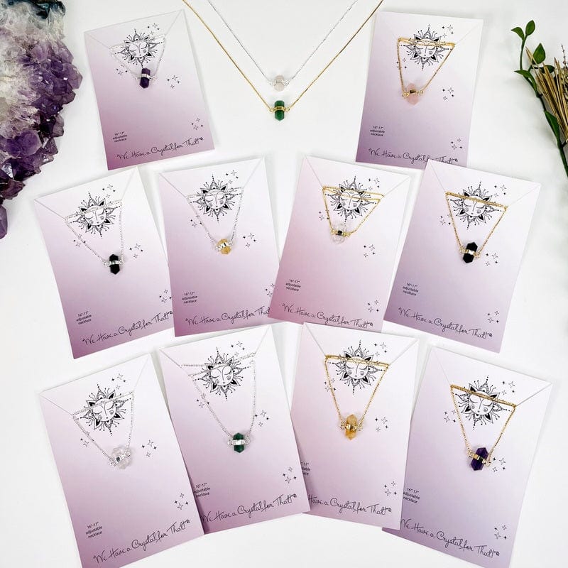 multiple double terminated crystal point necklaces displayed to show the differences in the crystals available
