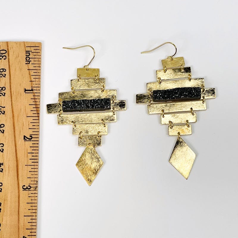 earrings next to a ruler for size reference 