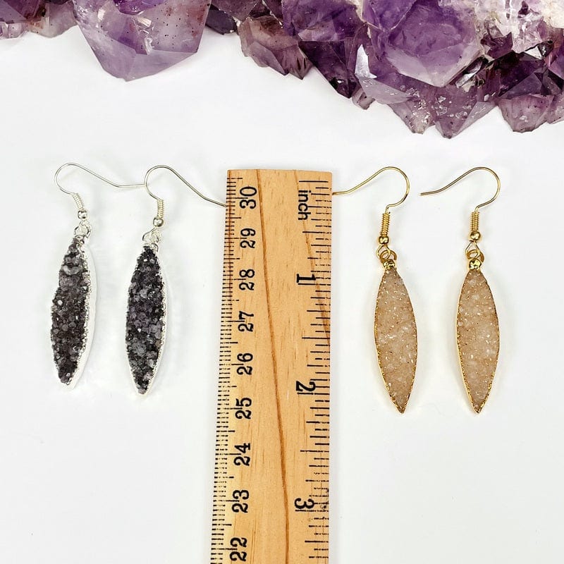 earrings next to a ruler for size reference 