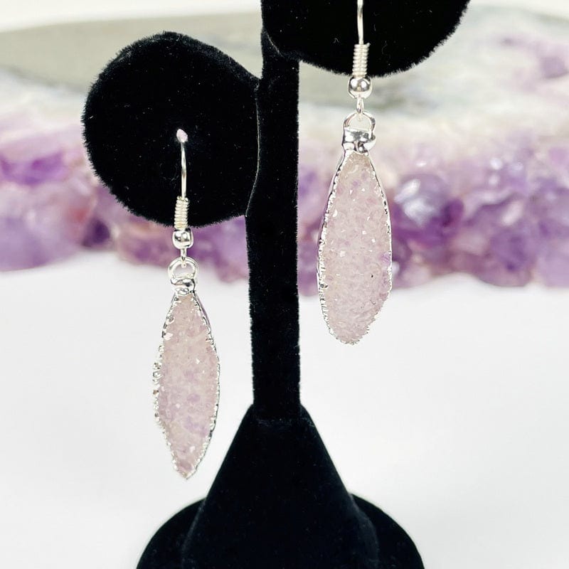 silver earrings displayed to show how they hang 