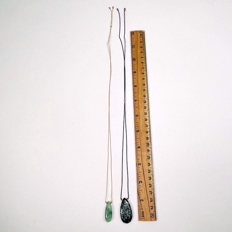 necklace next to a ruler for size reference 